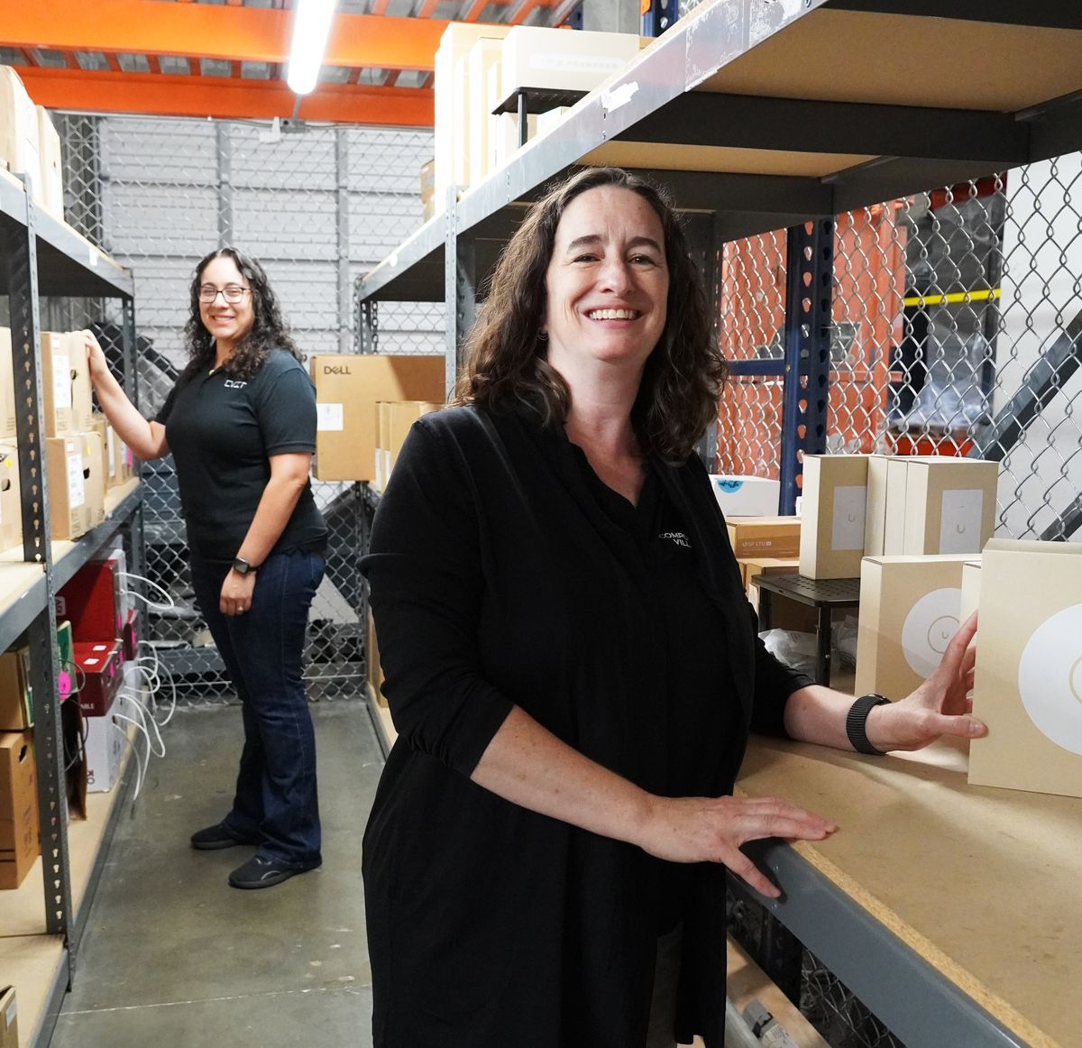 Two Computer Village staff pulling stock from the shelves at the Arrow warehouse