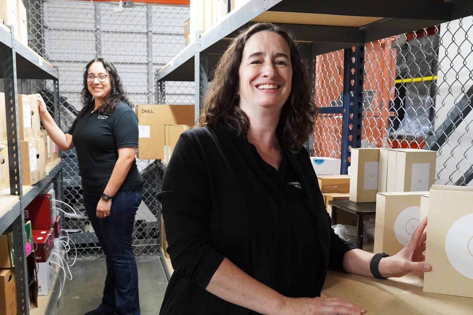 Two Computer Village staff at the shelves in the Arrow warehouse, pulling stock